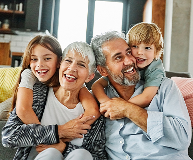 grandparents sitting on couch with their grandchildren keys to a successful retirement