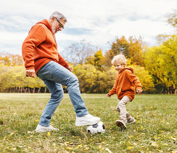 grandfather playing soccer with his grandson life insurance for retirement legacy