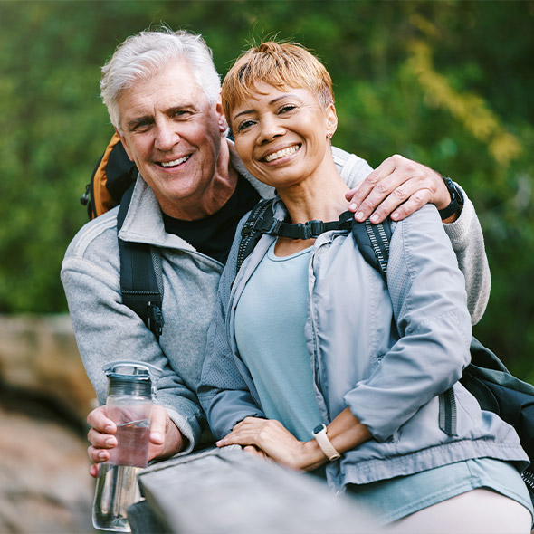senior couple posing together while on a hike