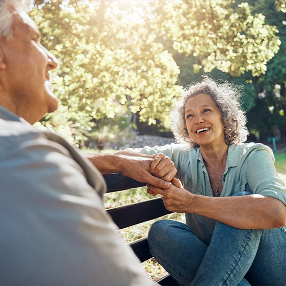 senior couple sitting on bench outdoors life insurance for retirement options